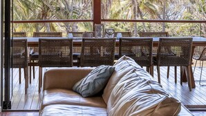 L’intérieur d’une maison de plage, avec un canapé, un coin repas et une pancarte indiquant « MAISON DE PLAGE ».
