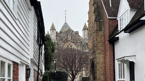 A cobblestone pathway leading to a historic building with a prominent tower and a large window. - Stylish Georgian Townhouse in Rye Citadel (Rye)
