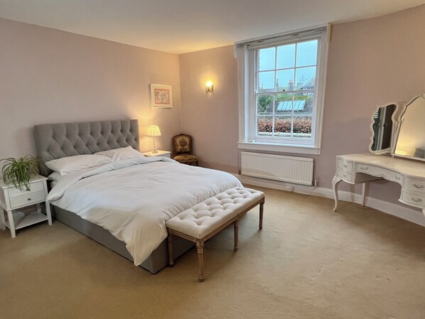 A bedroom with a bed, nightstand, lamp, chair, dresser, and window. - Stylish Georgian Townhouse in Rye Citadel (Rye)