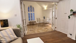 A living room with a sofa, a coffee table, and a dining area with chairs and a table. - Stylish Georgian Townhouse in Rye Citadel (Rye)