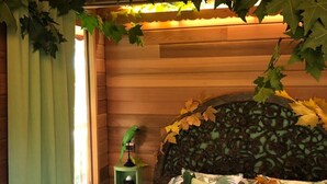 A cozy room with a bed, a nightstand, and a window with curtains. - Lake Como Dream Treehouse (Como)