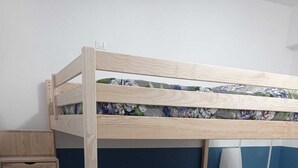 A bunk bed with a wooden ladder, a gray sofa, and a small white shelf unit. - Room rental for vacation, with bathroom in room 100 mt from subway  (Roma)