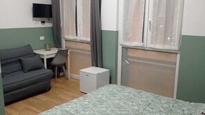 A compact room with a bed, a small table, a chair, a TV, and a window with curtains. - Room rental for vacation, with bathroom in room 100 mt from subway  (Roma)