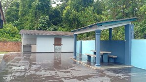 A covered outdoor area with a blue structure, a door, and a tiled floor.