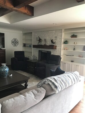 TV connectée, cheminée, livres, écrans d'ordinateur