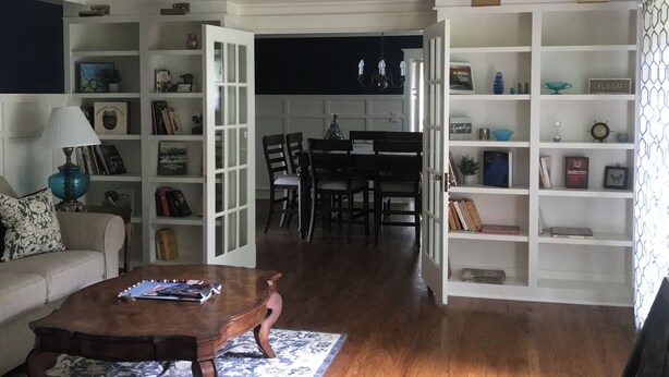 Een ruime woonkamer met een houten salontafel, een vloerkleed met dessin en een bordje met de tekst 'Welcome'.