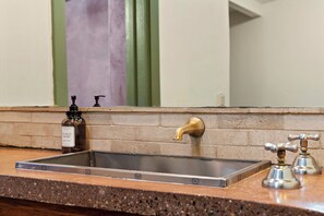 Un lavabo de salle de bain avec un distributeur de savon et un miroir.
