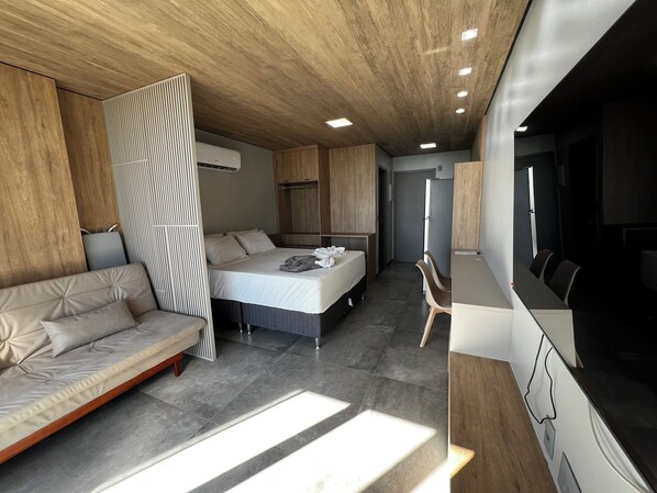 Une chambre d’hôtel moderne équipée d’un lit, d’un canapé, d’un bureau et d’une armoire.