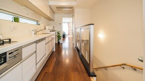 A modern kitchen with white cabinetry, a wooden floor, and a stainless steel refrigerator. - Upscale Sumida Retreat: Skytree Views, Workspaces & Premium Decor, 6 people (Sumida City)