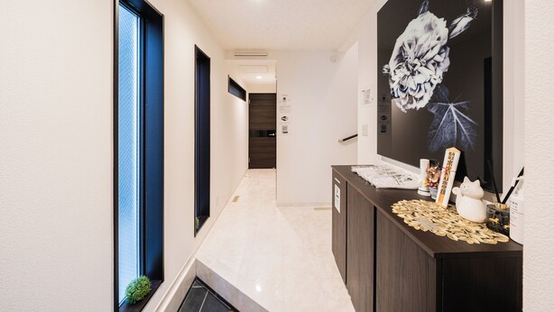 A hallway with a reception desk, a large floral artwork, and a small plant. - Upscale Sumida Retreat: Skytree Views, Workspaces & Premium Decor, 6 people (Sumida City)