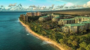 Ein Hotel an der Küste mit mehreren Gebäuden, einem Strand und Blick auf den Ozean.