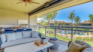 Ein modernes Wohnzimmer mit einer Couch, einem Couchtisch und Blick auf einen Pool sowie Hotelgebäude.