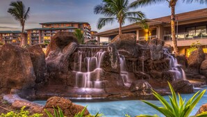 Ein Hotel mit Wassermusik, großen Felsen und einem Pool.
