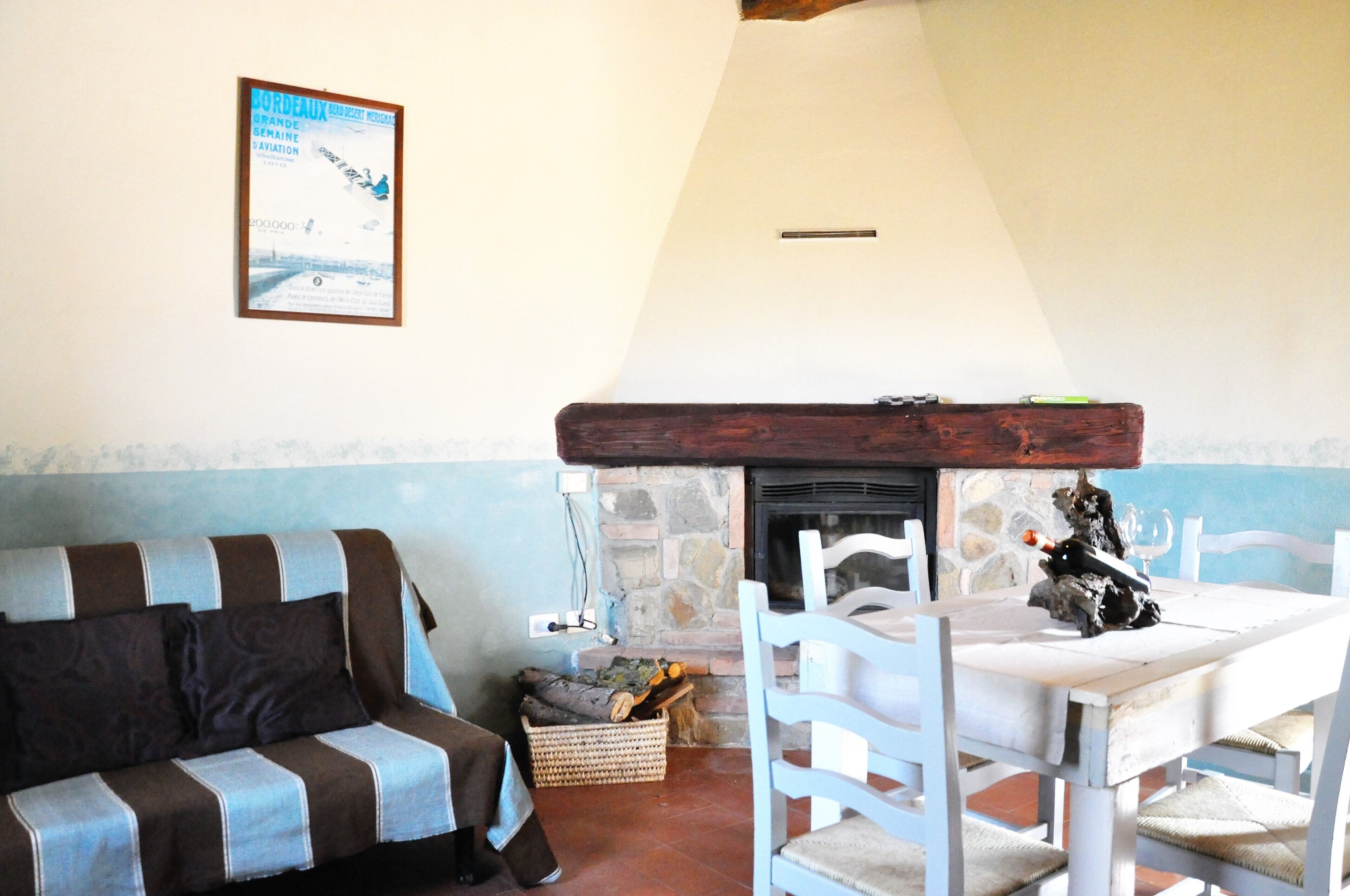 A cozy living room with a sofa, a dining table, and a fireplace.