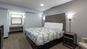 A modern hotel room with a large bed, a bedside table, a chair, a built-in desk, and a mirror. - Motel 6 Hickory, NC (Hickory)