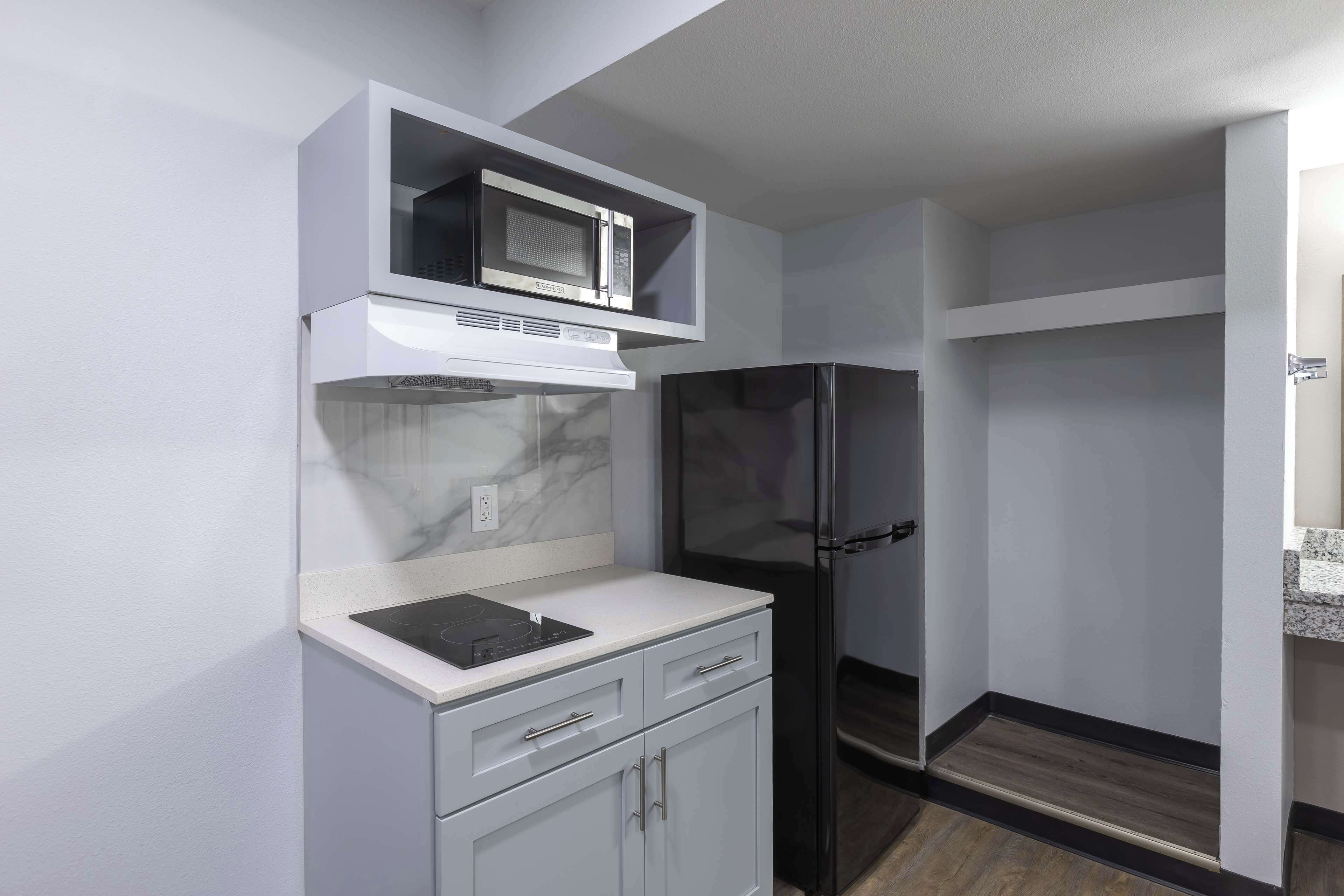 A compact kitchen with a microwave, stove, and refrigerator.