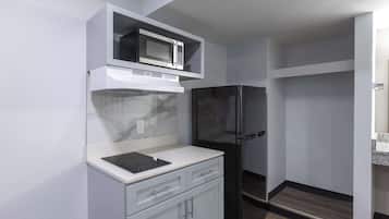 A compact kitchen with a microwave, stove, and refrigerator.