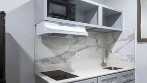 A modern kitchen with a built-in microwave, stove, and sink. - Studio 6 Hickory, NC (Hickory)