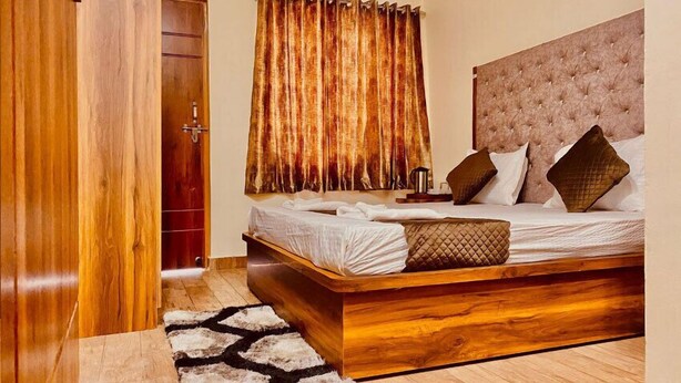 Quarto com estrutura de cama de madeira, cabeceira estofada e uma janela grande com cortinas.