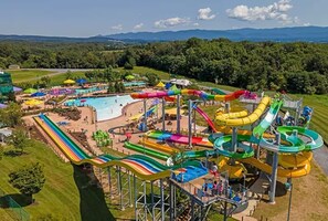 A water park with multiple slides and pools, surrounded by green hills and trees. - Mtn Views~Hot Tub~2 Game Rms~Fire Pit~Pet Friendly~Top of Mountain (McGaheysville)