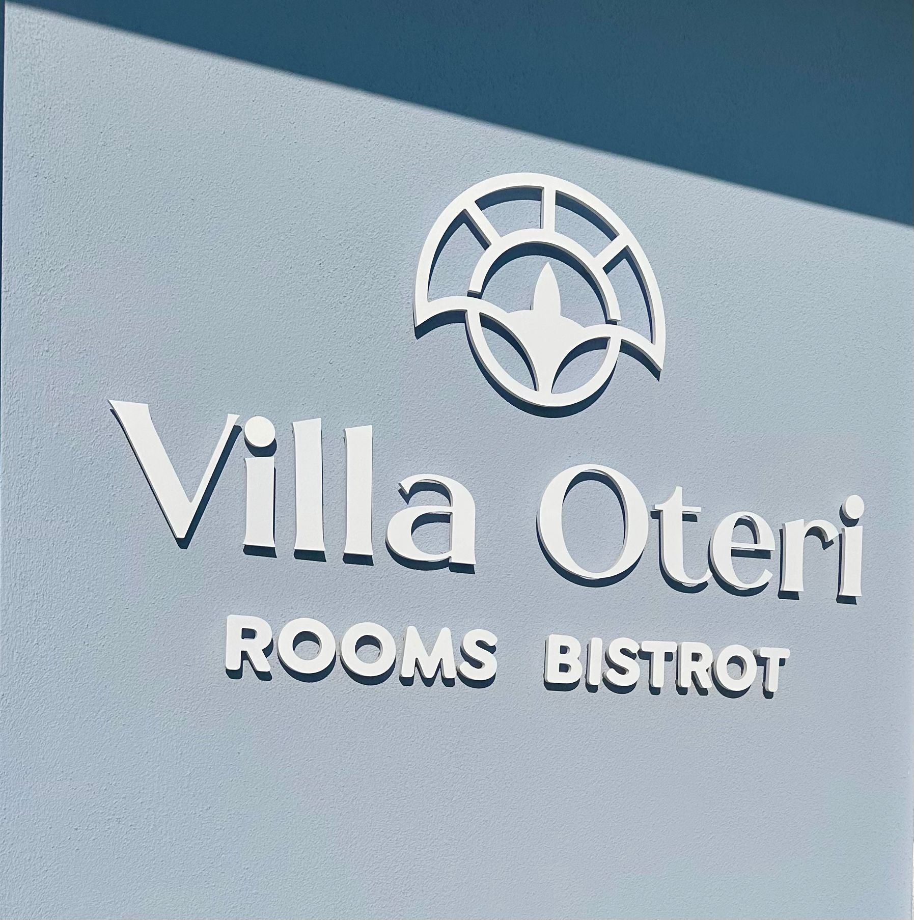 Señal para Villa Oteri con la inscripción "ROOMS BISTROT", indicando que el establecimiento ofrece servicios de alojamiento y restauración.