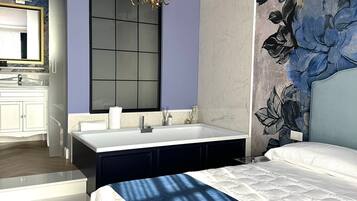 A modern bedroom with a large bed, a built-in vanity, and a large mirror.