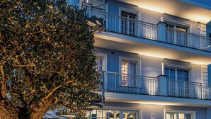 A multi-story hotel with a checkered outdoor area, outdoor seating, and a spiral staircase. - Villa Oteri Room & Bistrot (Bacoli)