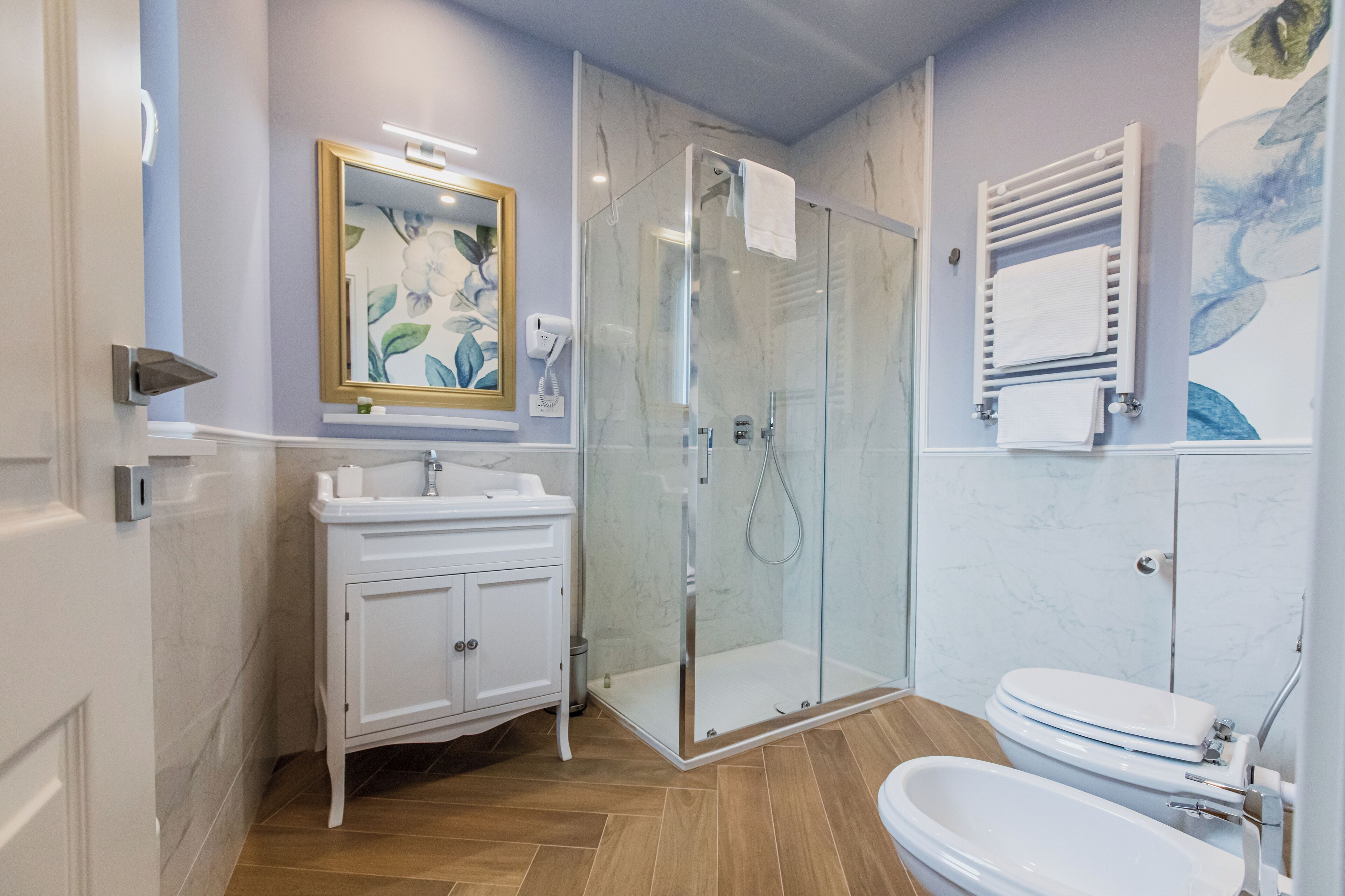 Un baño moderno con ducha de vidrio, lavamanos blanco y un inodoro.