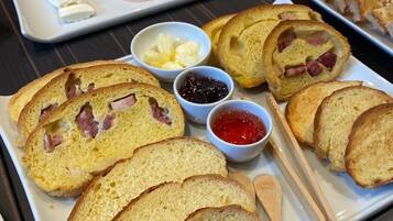 Una bandeja de desayuno con pan, jamón, queso y salsas.