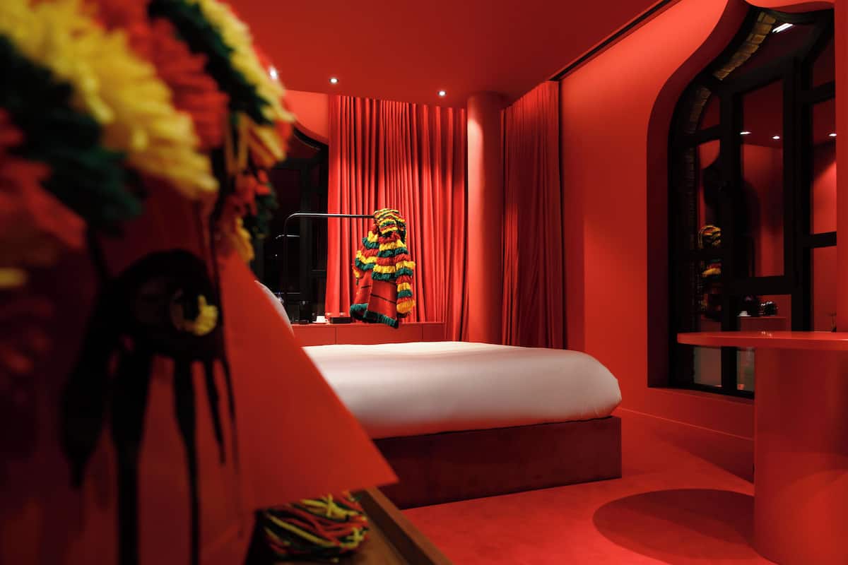 A room with a bed, a vanity, and a large mirror.