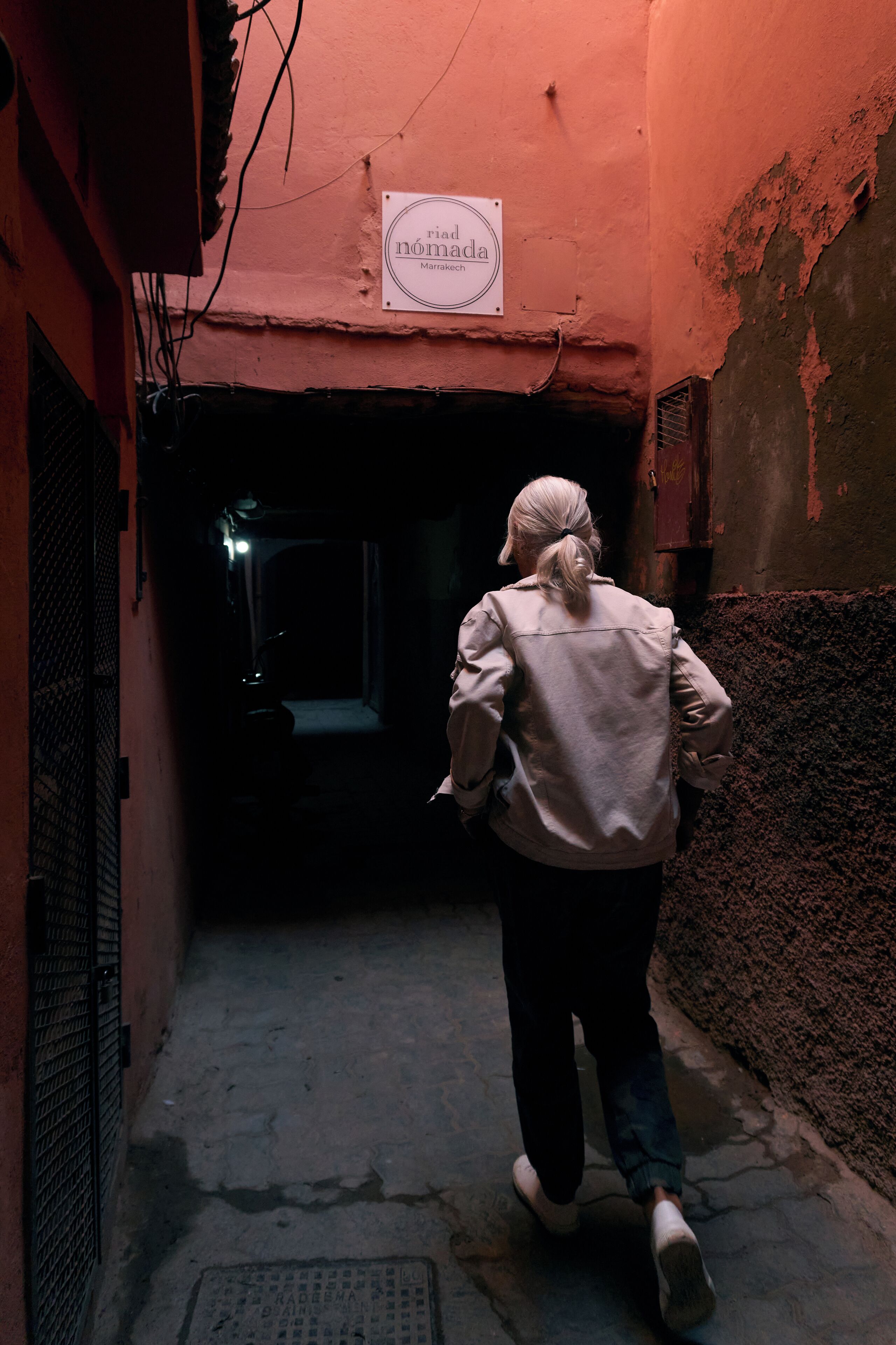 A narrow alleyway with a sign reading "Rial Nombada Marach."