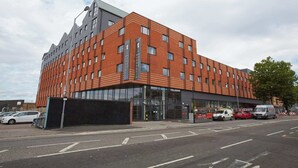Ein modernes Gebäude mit Backsteinfassade und großen Fenstern, vermutlich ein Hotel oder Bürogebäude.