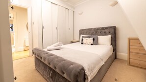 Ein Schlafzimmer mit einem großen Bett, einer Kommode und einem Kleiderschrank.