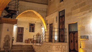 A stone staircase leading to an upper level with a wooden railing and a door marked "RECEPTION". - Colina Stone House (Ürgüp)