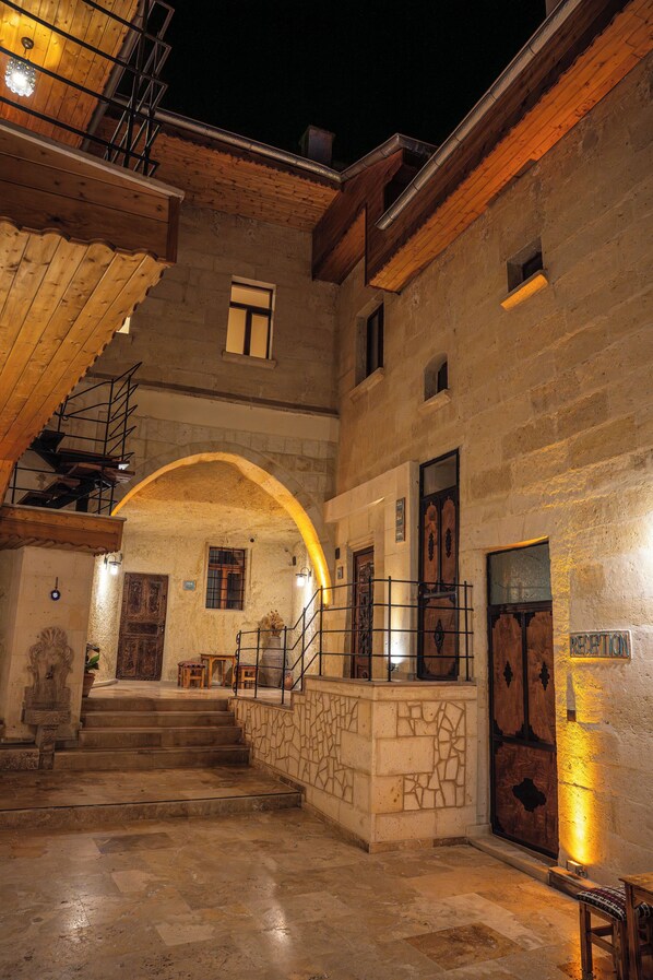 A stone staircase leading to an upper level with a wooden railing and a door marked "RECEPTION". - Colina Stone House (Ürgüp)