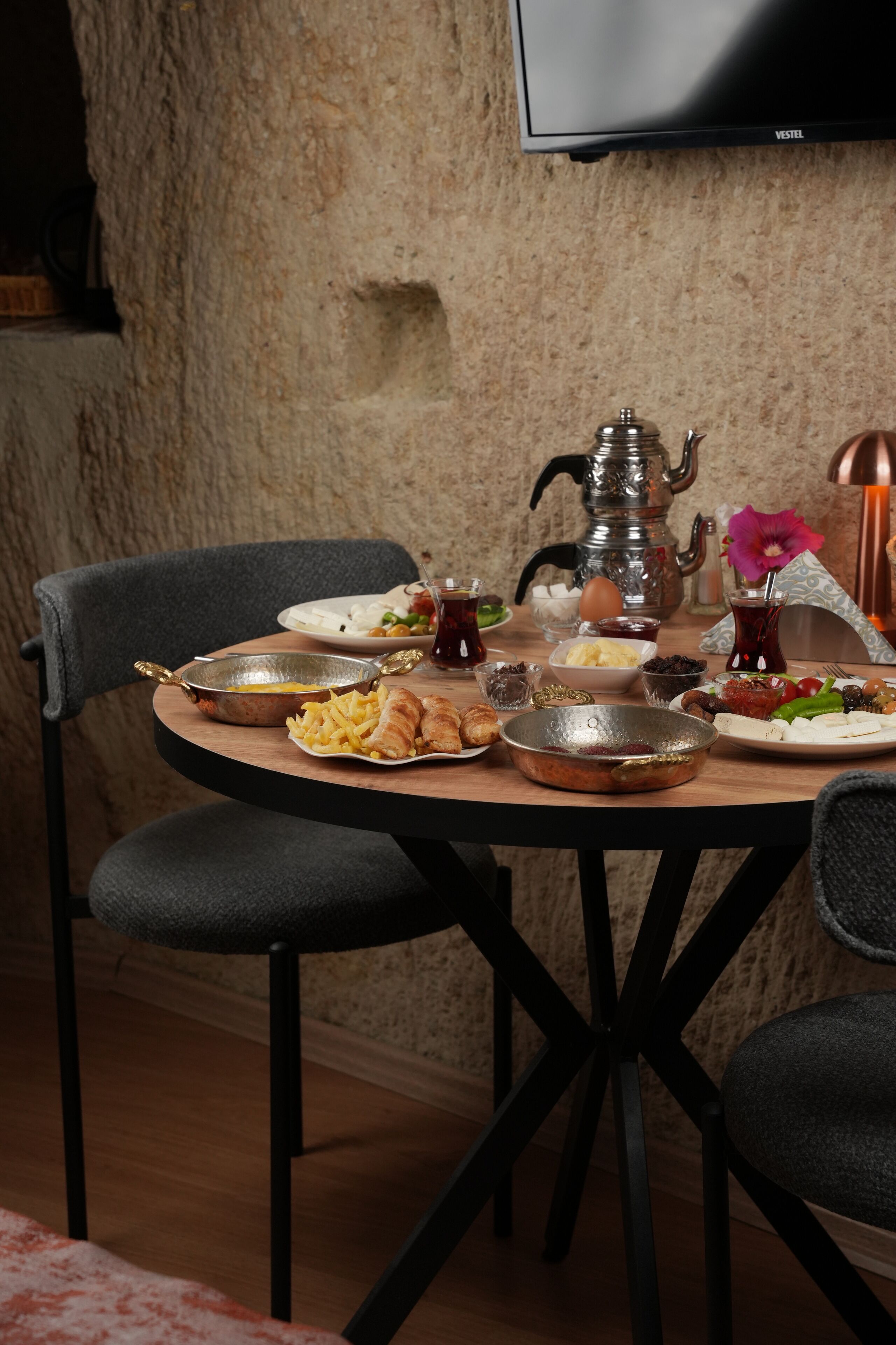 A dining table set with various dishes, a teapot, and a flower vase.