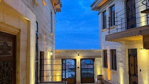 A courtyard with stone flooring, a staircase, and a view of the sky. - Colina Stone House (Ürgüp)