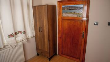 Un armario de madera, una puerta con vistas al paisaje y un radiador.