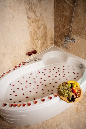 A bathtub with rose petals and fruits. - Colina Stone House (Ürgüp)