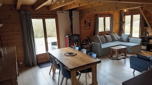 Um interior de cabana acolhedor, com área de refeições, sofá e lareira.