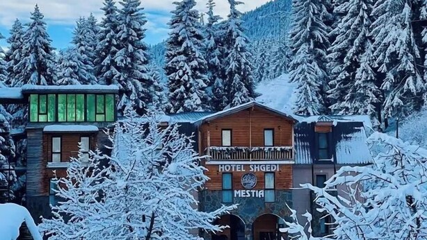 Ein Hotel namens "Hotel Shgedi" mit einer Holzfassade und einem Schild mit der Aufschrift "MESTIA".
