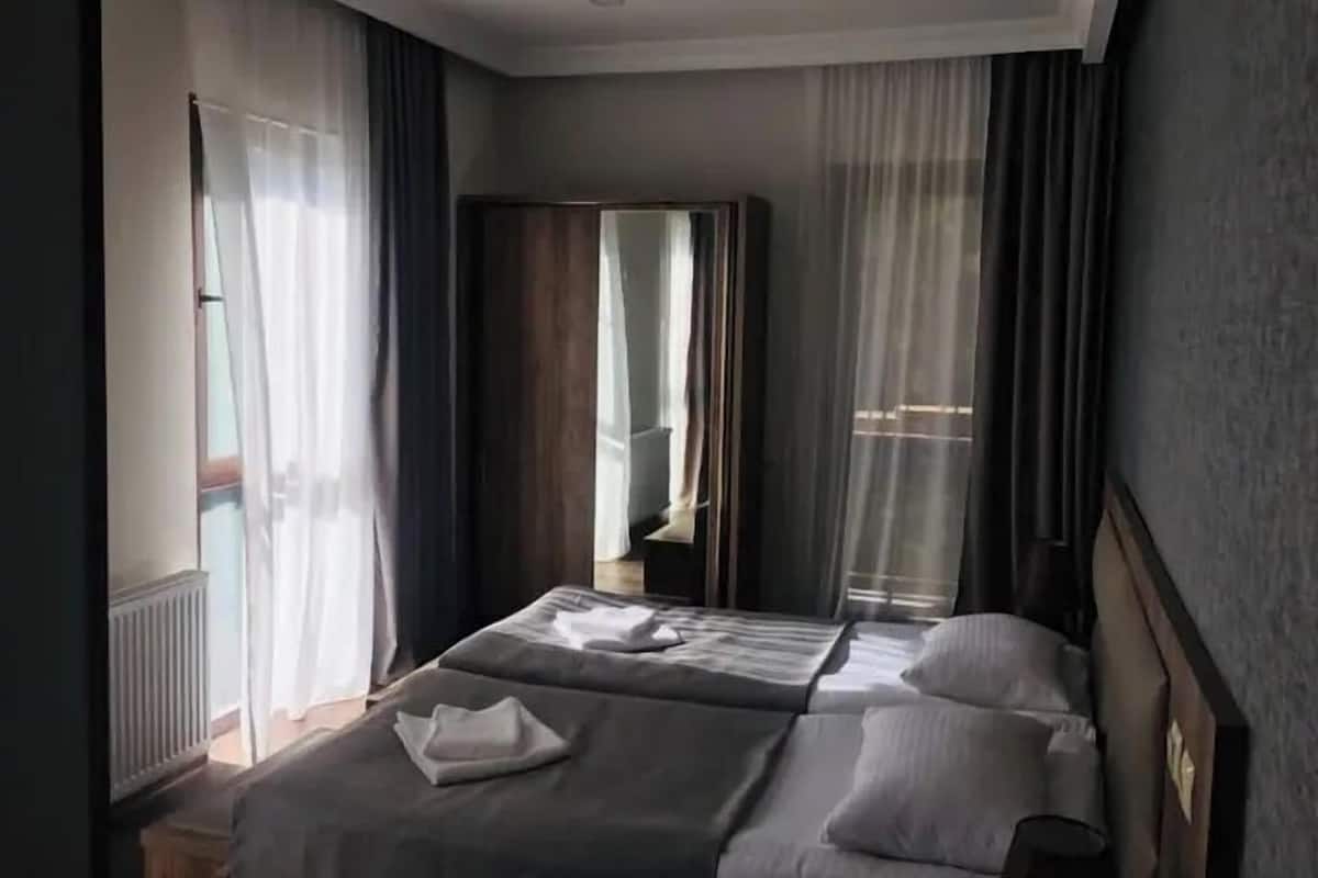 Ein Hotelzimmer mit zwei Betten, einem Kleiderschrank und einem Spiegel.