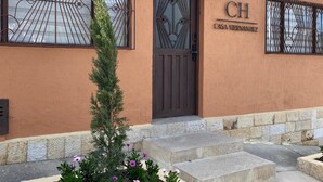 A building with a brown facade, a dark brown door, and a sign reading "CH CASA HERNANDEZ". - Spacious 9-bedroom house in wonderful La Calera with WiFi (La Calera)