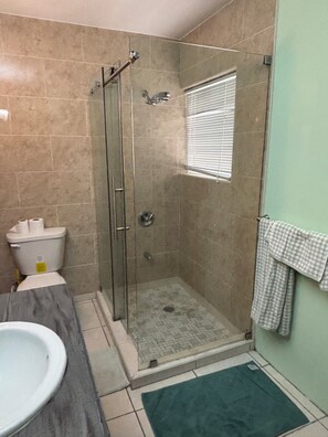 Een douche, handdoeken, zeep, toiletpapier