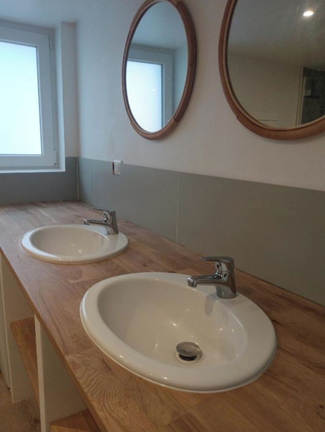 A bathroom with two sinks and two mirrors on a wooden countertop.