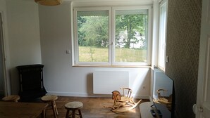 Una habitación con un ventanal grande, muebles de madera y un radiador.