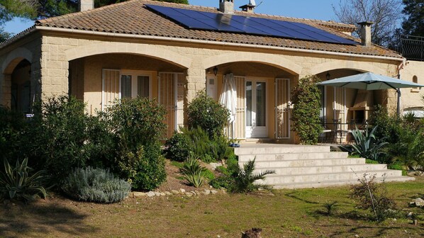 A Mediterranean-style house with a tiled roof, stone walls, and a front porch with steps leading to the entrance. - Cozy vacation home with a heated pool, hot tub, and sauna. Pets allowed. (Castillon-du-Gard)