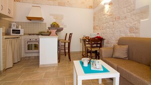 Une cuisine compacte équipée d’un four à micro-ondes, d’un four traditionnel et d’un petit coin repas avec une table et des chaises.
