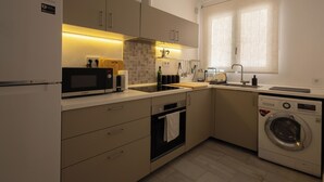 A modern kitchen with a Bosch microwave, oven, and washing machine. - Comfy Stylish Stay in Malaga (Malaga)
