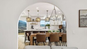 A modern kitchen with an arched doorway leading to a dining area.